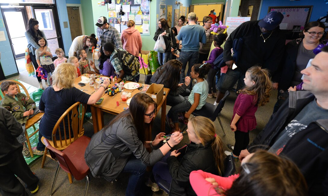 Airmen and their families attend a Month of the Military Child celebration in the Youth Center at Ellsworth Air Force Base, S.D., April 12, 2014. Military children were treated to an array of events including bouncy castles, music, prizes, refreshments and games with volunteers providing food, face-painting and ice cream. (U.S. Air Force photo by Senior Airman Zachary Hada/Released)