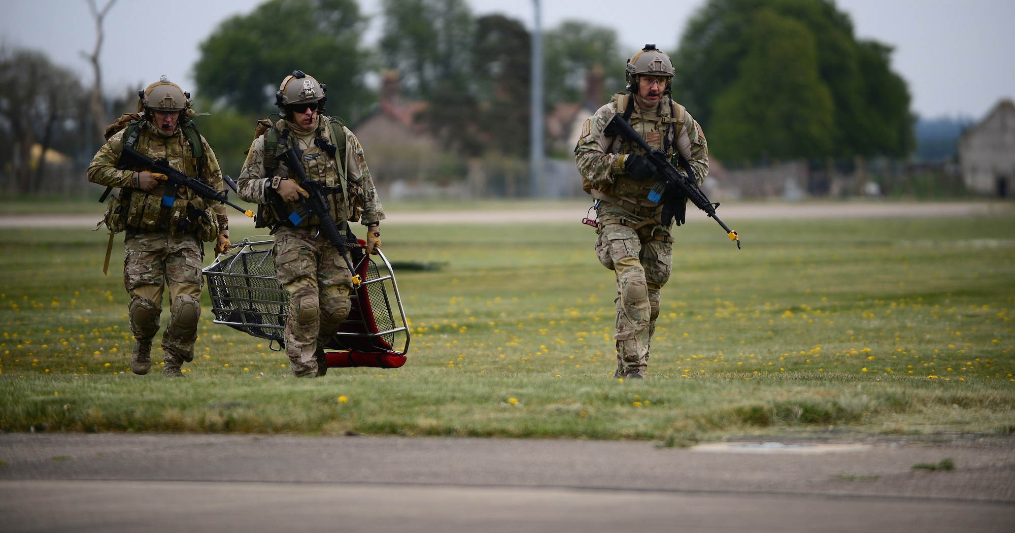 Chief Master Sgt. Chad Clark, Senior Master Sgt. Brandon Casteel and Maj. Patrick Gruber, 56th Rescue Squadron pararescue team members, run to a mock crash site during a combat search and rescue exercise at Royal Air Force Lakenheath, England, April 17, 2014. The rescue mission scenario included pararescue and security forces teams recovering a victim injured by an improvised explosive device. (U.S. Air Force photo by Staff Sgt. Emerson Nuñez/Released)