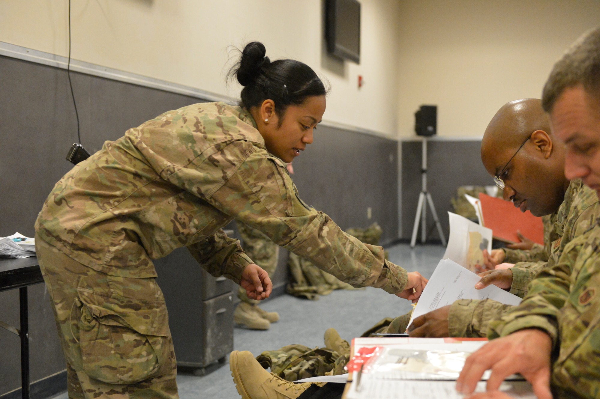 U.S. Air Force Senior Airman Desirae Faasavalu helps an Airmen arriving at Bagram Airfield, Afghanistan, with a question about the in-processing paperwork, April 17, 2014. Faasavalu is assigned to the 455th PERSCO (Personnel Support for Contingency Operations) team, and is responsible for in-processing of Airmen arriving at Bagram.(U.S. Air Force photo by Senior Master Sgt. Gary J. Rihn/Released)  