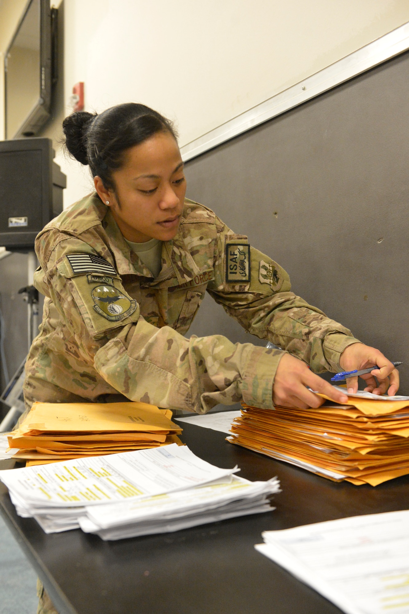 U.S. Air Force Senior Airman Desirae Faasavalu sorts through packets of incoming Airman information at Bagram Airfield, Afghanistan, April 2, 2014. Faasavalu is assigned to the 455th PERSCO (Personnel Support for Contingency Operations) team, and is responsible for in-processing of Airmen arriving at Bagram.(U.S. Air Force photo by Senior Master Sgt. Gary J. Rihn/Released)