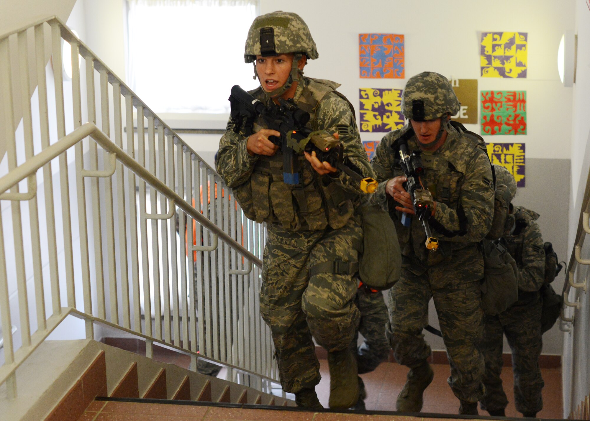 Senior Airman Tarah Roth, 31st Security Forces Squadron defender, and a team of SFS defenders race to the third floor during an active shooter training exercise at the Aviano Air Base Elementary School, April 19, 2014. The SFS Airmen culminated their week-long active shooter training with a hands-on exercise that tested their abilities to respond in a stressful situation. (U.S. Air Force photo/Tech. Sgt. Eric Donner)
