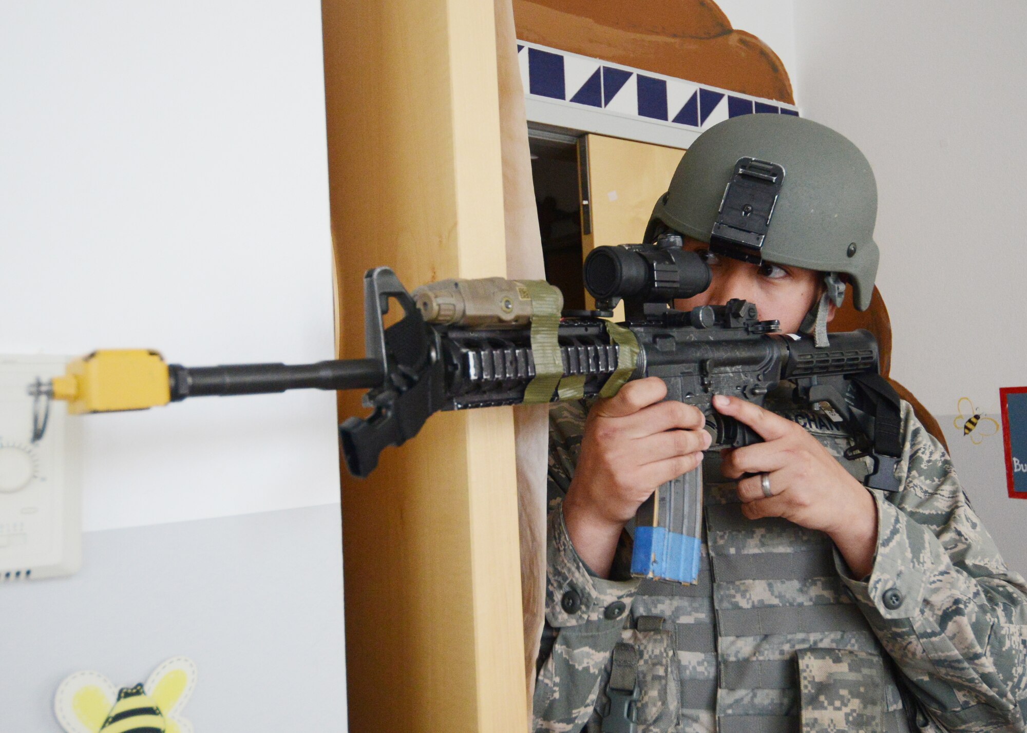 Airman 1st Class Matthew Pachan, 31st Security Forces Squadron defender, stands guard while fellow defenders clear a classroom during an active shooter training exercise at the Aviano Air Base Elementary School, April 19, 2014. The SFS Airmen culminated their weeklong active shooter training with a hands-on exercise that tested their abilities to respond in a stressful situation. The training was made as real as possible with simulated rounds and victims spread throughout the school for the defenders to locate and treat. (U.S. Air Force photo/Tech. Sgt. Eric Donner)