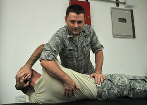 Air Force Capt. Jared P. Bueche, 380th Expeditionary Medical Group physical therapist, demonstrates a treatment technique on a volunteer from the 380 EMG. Bueche is the first physical therapist to offer clinical services at the 380th Air Expeditionary Wing. (U.S. Air Force photo by Senior Master Sgt. Eric Peterson)