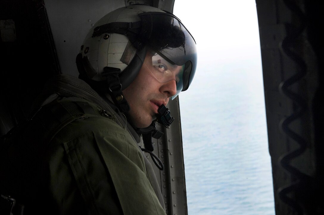 U.S. Marine Corps Cpl. Joey Hernandez-Rogers looks out of a CH-53E ...