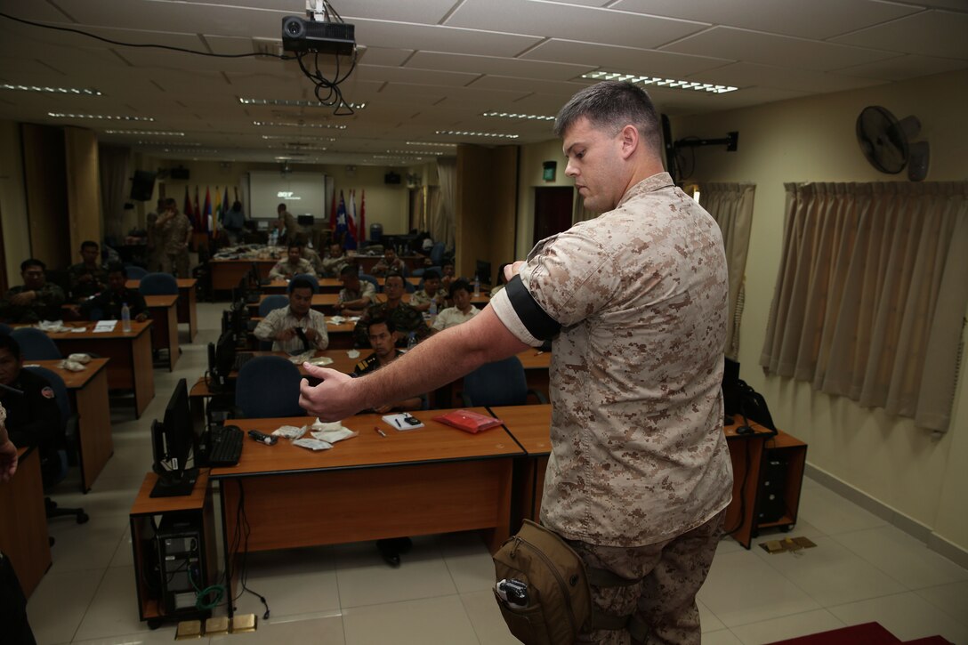 U.S. Navy Petty Officer 2nd Class Ryan W. Marczynski demonstrates how to properly apply a tourniquet during a practical application seminar March 20 as part of Cambodia Medical Exercise 14-1 in Phnom Penh, Cambodia. The seminar is part of a weeklong medical subject-matter expert exchange focused on preparing and planning for humanitarian assistance and disaster relief efforts. During the seminar, participants learned how to properly use and improvise certain medical equipment, such as tourniquets, to better support first aid and triage procedures. Marczynski is a corpsman with 3rd Medical Battalion, 3rd Marine Logistics Group, III Marine Expeditionary Force. 