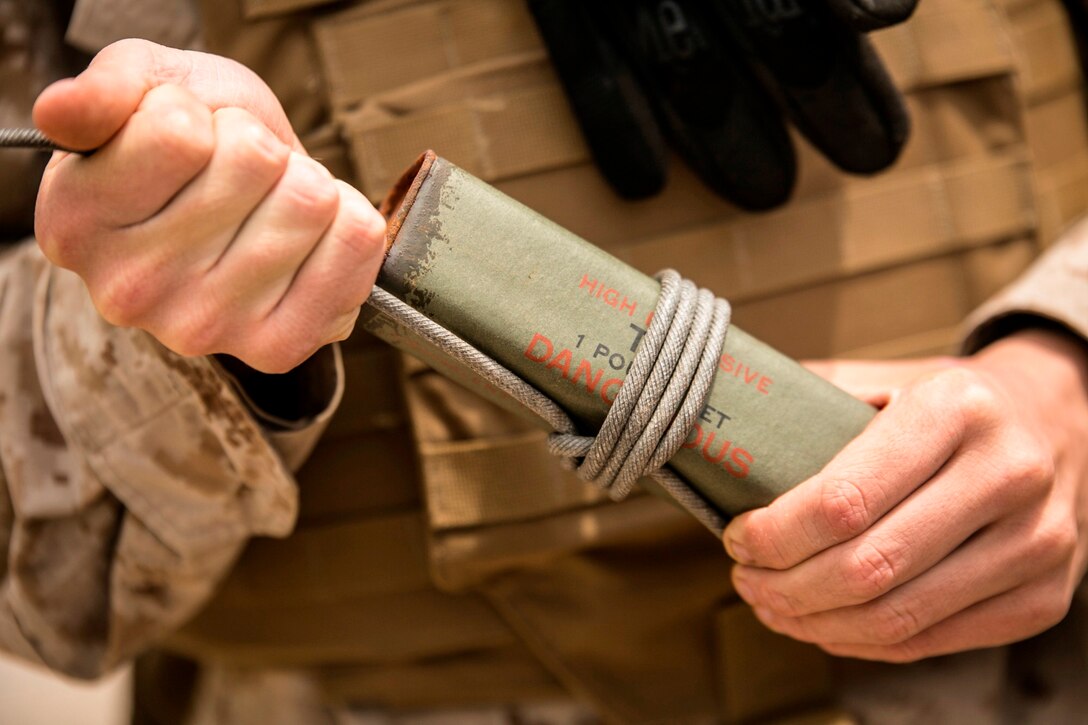 A Marine ensures detonation cord is tied properly to a block of TNT April 15 during a four-day basic demolition course at Camp Schwab. With the safety of Marines paramount, properly knowing how to handle and detonate explosives can be the difference between life and death during training and real-world operations, according to Sgt. Shawn D. Olewiler, a combat engineer with Marine Wing Support Squadron 172, Marine Aircraft Group 36, 1st Marine Aircraft Wing, III Marine Expeditionary Force. 