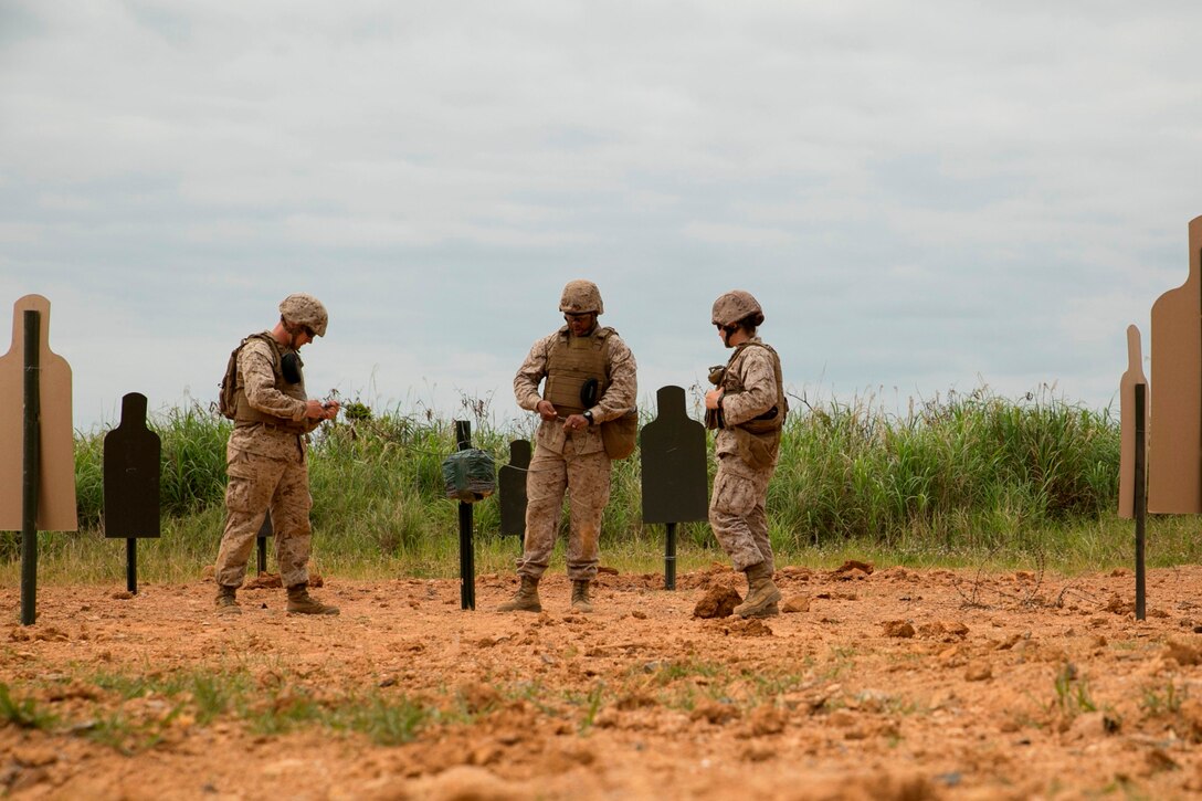 Marines initiate the time fuse connected to an omnidirectional charge surrounded by targets April 16 at Camp Schwab during a four-day basic demolition course. The omni charge, also known as a “Frankenstein pie,” sends shrapnel flying in all directions within its blast radius. The Marines participating in the training are with various units assigned to III Marine Expeditionary Force. 