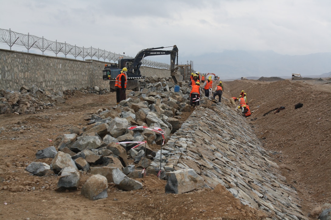 Deployed members of the U.S. Army Corps of Engineers oversee the construction of a drainage ditch around the perimeter walls of the new Afghanistan National Army (ANA) base in Deh Rawood, Camp Hadrian.