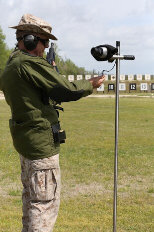 Col. Gregory H. Kitchens, officer in charge and marksmanship training unit and shooting for Marine Corps Forces Reserve Division Team, checks his time before firing the National Match M16A4 service rifle with iron sights at the 200-yard line during the individual rifle portion of the 2014 Marine Corps Championships from April 14-16 aboard the Weapons Training Battalion ranges at Stone Bay. Kitchens is one of 84 competitors, and they competed in three different categories. The individual rifle match, the individual pistol match and the team rifle and pistol match. The individual rifle match and team match are shot from the 200-yard line, 300-yard line and 600-yard line. The match rifle weighs approximately 17 pounds, with a stainless steel barrel with both weighted hand guards and butt stock. During competition marksmanship, competitors are supplied with unique shooting jackets and non-slip leather rifle slings that provide additional stability, and long-distance scouting scopes to sight shots at distances more than 600 yards. (U.S. Marine Corps photo by Sgt. Alicia R. Leaders/Released)