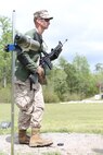 Cpl. Austin J. Kirby, an Aircraft Rescue and Fire Fighting technician with Marine Wing Support Detachment, Marine Corps Air Station Kaneohe Bay, Hawaii, Pacific Division Team, stands in preparation for moving to the sitting position upon firing the National Match M16A4 service rifle with iron sights at the 300-yard line rapid fire during the individual rifle portion of the 2014 Marine Corps Match Championships from April 14-16 aboard the Weapons Training Battalion ranges at Stone Bay. Kirby is one of 84 competitors, and they competed in three different categories. The individual rifle match, the individual pistol match and the team rifle and pistol match. The individual rifle match and team match are shot from the 200-yard line, 300-yard line and 600-yard line. The match rifle weighs approximately 17 pounds, with a stainless steel barrel with both weighted hand guards and butt stock. During competition marksmanship, competitors are supplied with unique shooting jackets and non-slip leather rifle slings that provide additional stability, and long-distance scouting scopes to sight shots at distances more than 600 yards. (U.S. Marine Corps photo by Sgt. Alicia R. Leaders/Released)