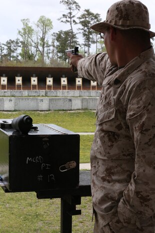 Sgt. Richard N. West, a drill instructor from Marine Corps Recruit Depot Parris Island, S.C., Eastern Division Team, fires the National Match M1911 .45 caliber service pistol one-handed, with his other hand placed in the pocket for stability, during the individual pistol portion of the 2014 Marine Corps Match Championships from April 14-16 aboard the Weapons Training Battalion ranges at Stone Bay. The individual pistol match is shot at the 25-yard line and 50-yard line, and must be shot one-handed, and the other hand can be placed in the pocket for stability. West is one of 84 competitors, and they competed in three different categories. The individual rifle match, the individual pistol match and the team rifle and pistol match. (U.S. Marine Corps photo by Sgt. Alicia R. Leaders/Released)