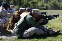(From left to right) Capt. Andrew D. Blackwell, assistant disbursing officer with Combat Logistics Regiment 37, 3rd Marine Logistics Group, Camp Foster, Japan, watches rounds go down range as Gunnery Sgt. Barry A. Worster, motor transportation chief with 3rd Combat Assault Battalion, 3rd Marine Division, Marine Corps Base Okinawa, Japan, and Sgt. Juan A. Quintero, correction specialist with Headquarters Service Battalion, MCB Camp Butler, and Chief Warrant Officer 3 Scott W. Richards, corrections officer with Headquarters Service Battalion, Marine Corps Base Camp Butler, Far East Division Team, fire rounds with the National Match M16A4 service rifle with iron sights on the 600-yard line during the team rifle match portion of the 2014 Marine Corps Match Championships, April 16, aboard the Weapons Training Battalion ranges at Stone Bay. (U.S. Marine Corps photo by Sgt. Alicia R. Leaders/Released)