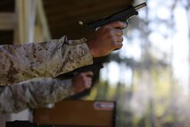 Sgt. Richard N. West, a drill instructor from Marine Corps Recruit Depot Parris Island, S.C., and Capt. Stanley C. Wisniewski, Marine Corps Recruit Depot Parris Island, S.C., shooting team officer in charge, Eastern Division Team, fire the National Match M1911 .45 caliber service pistol one-handed, during the team pistol match portion of the 2014 Marine Corps Match Championships, April 16, aboard the Weapons Training Battalion ranges at Stone Bay. Eighty-four competitors competed in the championships in three different categories. The individual rifle match, the individual pistol match and the team rifle and pistol match. (U.S. Marine Corps photo by Sgt. Alicia R. Leaders)