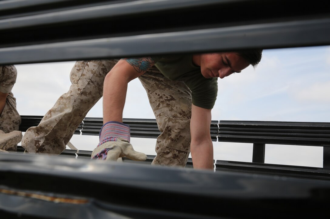 A Marine with 3rd Marine Aircraft Wing loads an old concrete slab onto a truck to be hauled away for Earth Day near Marine Corps Air Station Miramar, Calif., April 22. Marines and Sailors also picked up litter near the roads.