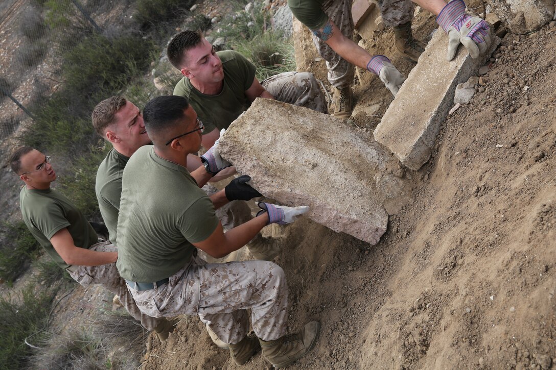 Marines and Sailors with 3rd Marine Aircraft Wing and Marine Corps Air Station Miramar, Calif., help clean up the area near the installation, April 22. The Marines removed old concrete slabs and litter from the roads and nearby areas for Earth Day.