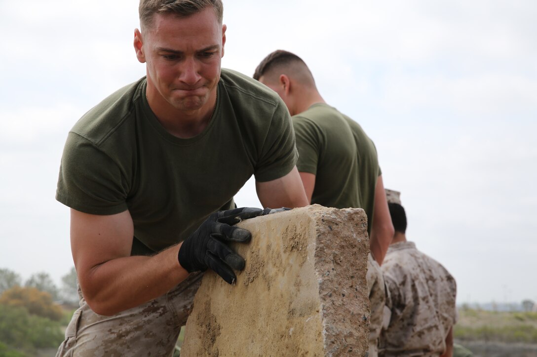 Seaman Valentin Zherelyev, a corpsman with Marine Fighter Attack Squadron (All Weather) 225, moves an old concrete slab for Earth Day near Marine Corps Air Station Miramar, Calif., April 22. Marines and Sailors also picked up litter near the roads.