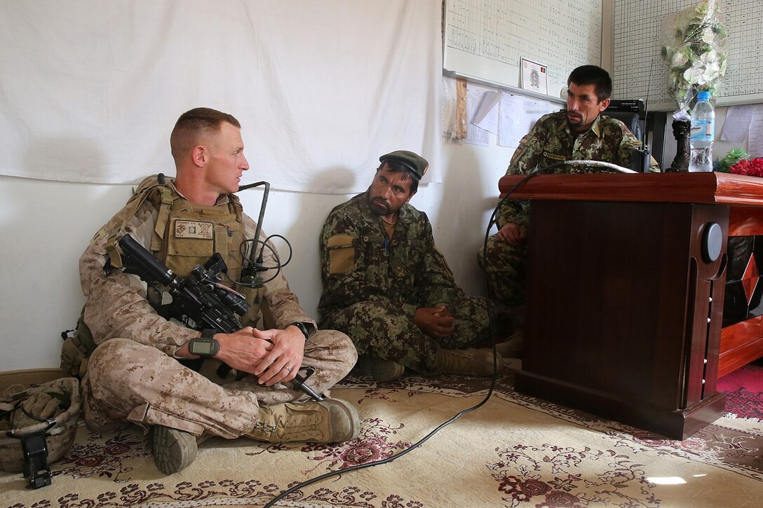 Captain Scott Stewart, commanding officer, Weapons Company, 1st Battalion, 7th Marine Regiment, and a native of El Cajon, Calif., speaks with senior Afghan National Army officers during a mission in Helmand province, Afghanistan, April 17. The company's two-day mission was to disrupt lethal enemy aid and to search three compounds of interest in an area suspected of Taliban influence. The compounds were suspected to contain a homemade-explosive lab, a cache for narcotics and be home to local Taliban leadership.