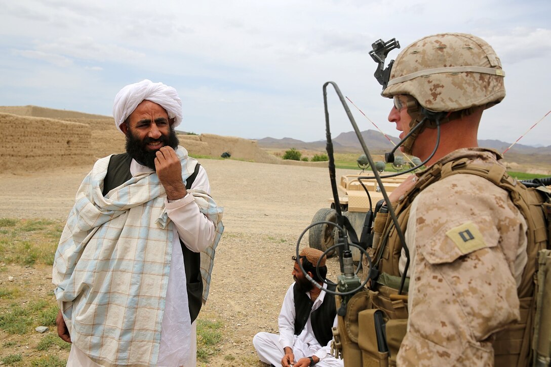 Captain Scott Stewart, commanding officer, Weapons Company, 1st Battalion, 7th Marine Regiment, and a native of El Cajon, Calif., speaks with a local Afghan to gather intelligence during a mission in Helmand province, Afghanistan, April 17. The company's two-day mission was to disrupt lethal enemy aid and to search three compounds of interest in an area suspected of Taliban influence. The compounds were suspected to contain a homemade-explosive lab, a cache for narcotics and be home to local Taliban leadership.