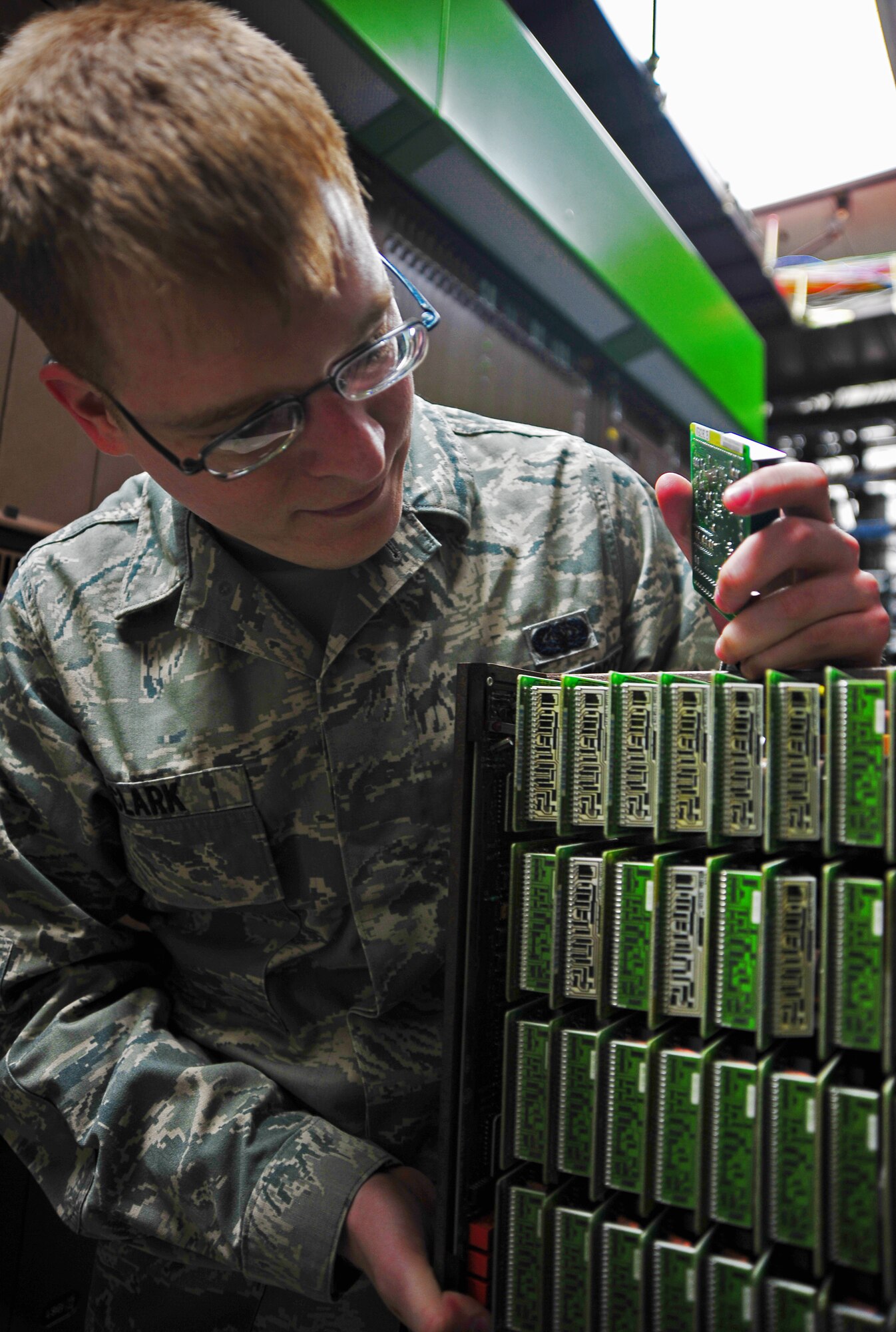 U.S. Air Force Senior Airman Matthew Clark, 35th Communications Squadron cyber transport systems journeyman, opens a voice card panel as part of a maintenance job at Misawa Air Base, Japan, April 22, 2014. The panel is part of the Line Concentrating Module, a voice suite component that enables call processing for multiple users. (U.S. Air Force photo/Senior Airman Jose L. Hernandez-Domitilo)
