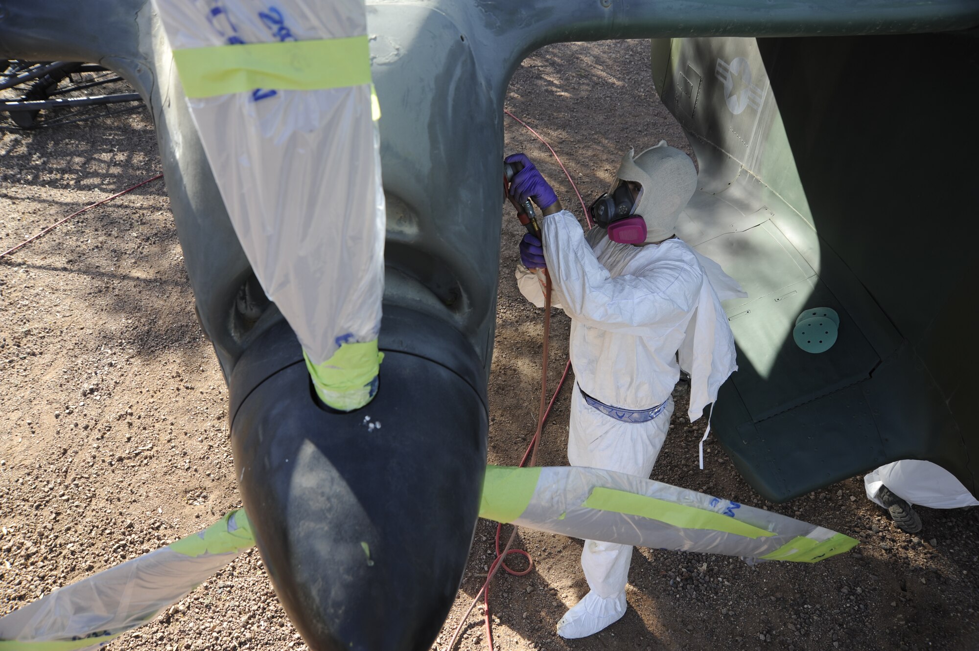 U.S. Air Force Senior Airman Edward Lawrence, 355th Equipment Maintenance Squadron aircraft structural maintainer, strips paint off an OV-10A Bronco at Davis-Monthan Air Force Base, Ariz., April 22, 2014. The aircraft is displayed at Heritage Park along with a Cessna O-1 Bird Dog, both are loaned to D-M by the National Museum of the Air Force. (U.S. Air Force photo by Airman 1st Class Betty R. Chevalier/released)
