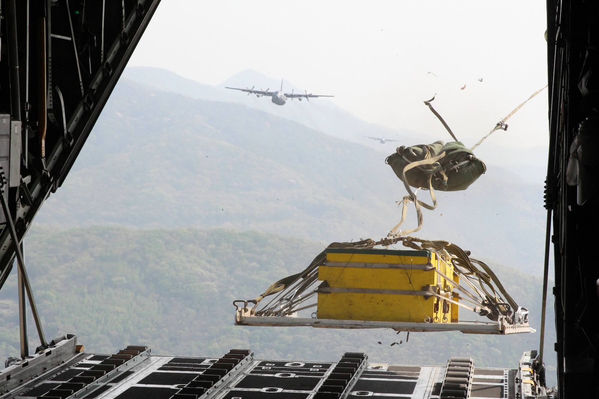 Yokota Air Base C-130 Hercules deploy a heavy equipment payload over Gwangju Air Base, Republic of Korea, during Exercise Max Thunder, April 18, 2014. Max Thunder is the Air Component-led portion of Exercise Foal Eagle, a series of joint and bilateral exercises that integrate ground, air, naval, expeditionary and special operations. (U.S. Air Force photo by 2d Lt. Ashley Wright/Released)