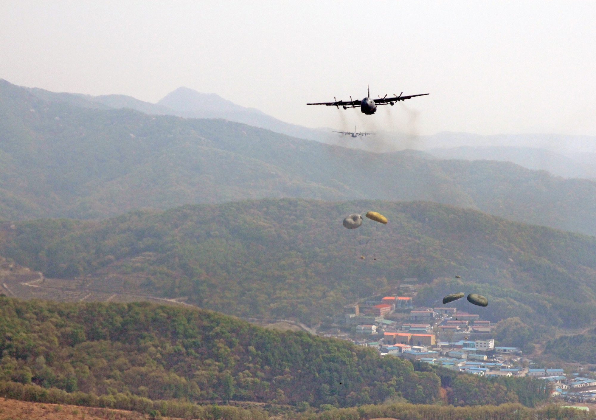 Yokota Air Base C-130 Hercules perform an airdrop over Gwangju Air Base, Republic of Korea, during Exercise Max Thunder, April 18, 2014. Max Thunder is the Air Component-led portion of Exercise Foal Eagle, a series of joint and bilateral exercises that integrate ground, air, naval, expeditionary and special operations. (U.S. Air Force photo by 2d Lt. Ashley Wright/Released)