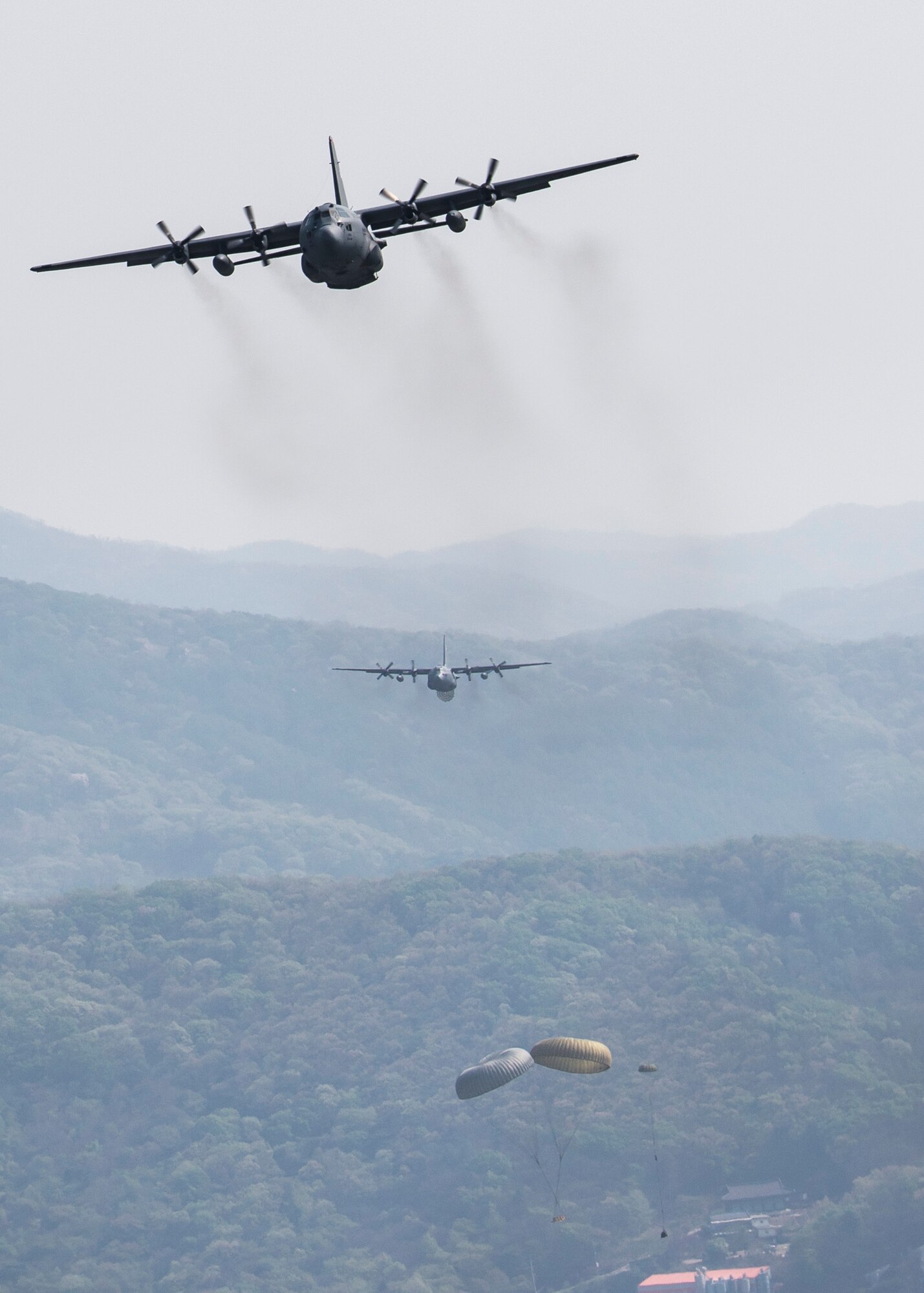 Yokota Air Base C-130H Hercules drop heavy equipment payloads over the Republic of Korea during Exercise Max Thunder, April 18, 2014. Max Thunder is a bilateral air exercise designed to improve interoperability between regional air assets during contingency operations. (U.S. Air Force photo by Capt. Raymond Geoffroy/Released)