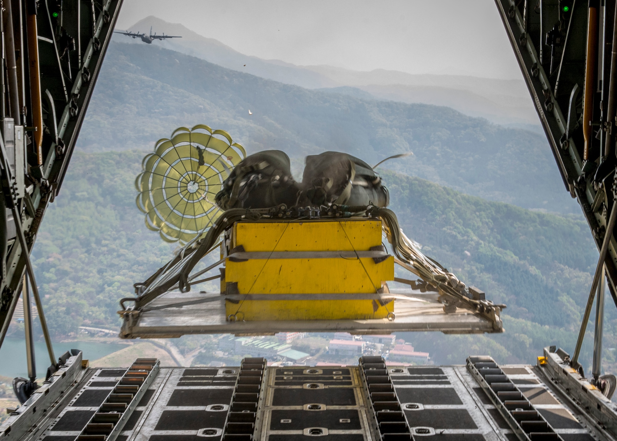 A heavy equipment payload drops from a Yokota Air Base C-130H Hercules over the Republic of Korea during Exercise Max Thunder, April 18, 2014. Max Thunder is a bilateral air exercise designed to improve interoperability between regional air assets during contingency operations. (U.S. Air Force photo by Capt. Raymond Geoffroy/Released)