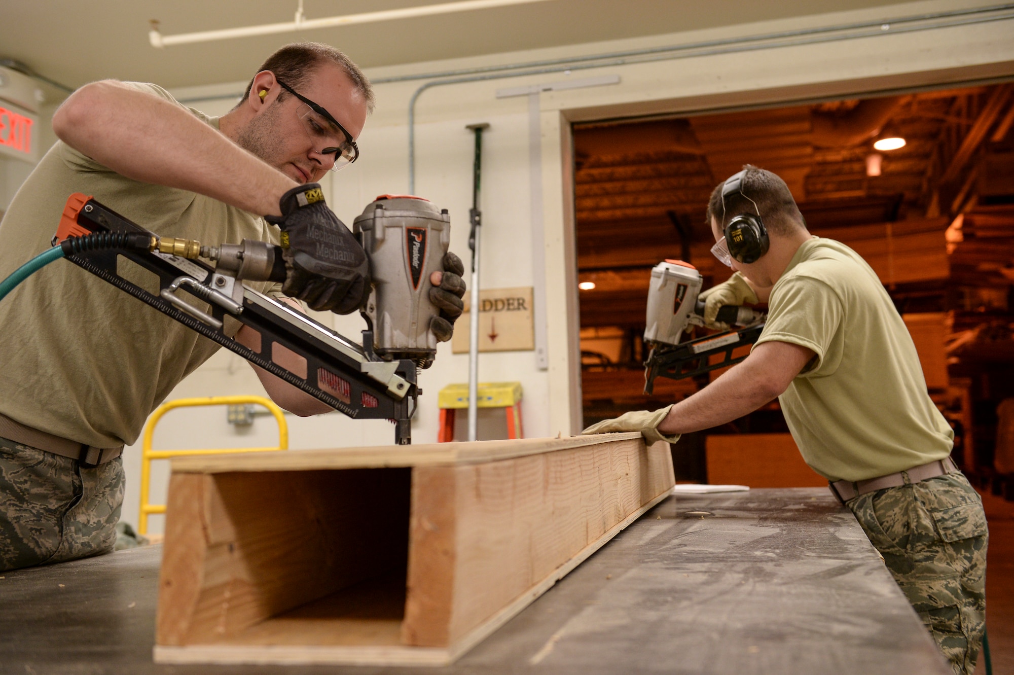 U.S. Air Force Airman 1st Class Paul Bissett and Senior Airman Raymond Ramirez, 354th Logistics Readiness Squadron traffic management specialists, assemble end blocking for an ammunition container at the 354th LRS warehouse April 17¬, 2014, Eielson Air Force Base, Alaska. Bissett and Ramirez  fabricated boxes to protect ammunition during transport. (U.S. Air Force photo by Senior Airman Peter Reft/Released)