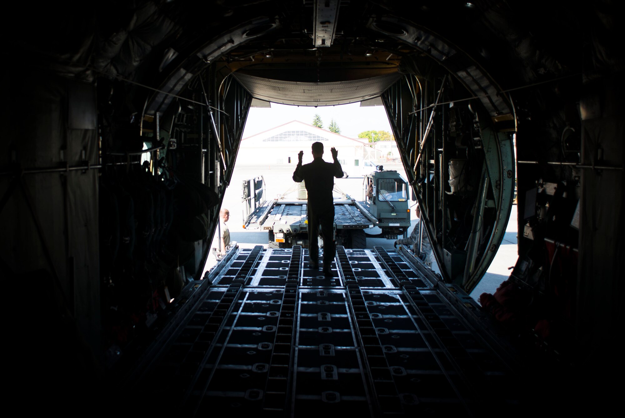 A loadmaster with the 36th Airlift Squadron marshalls cargo on to a C-130 Hercules April 23, 2014 at Yokota Air Base, Japan. The sortie took off in support of Max Thunder, a bilateral aerial training exercise that trains U.S. and Republic of Korea Air Force pilots to work closer together against a hostile force. (U.S. Air Force photo by Staff Sgt. Chad C. Strohmeyer/Released)
