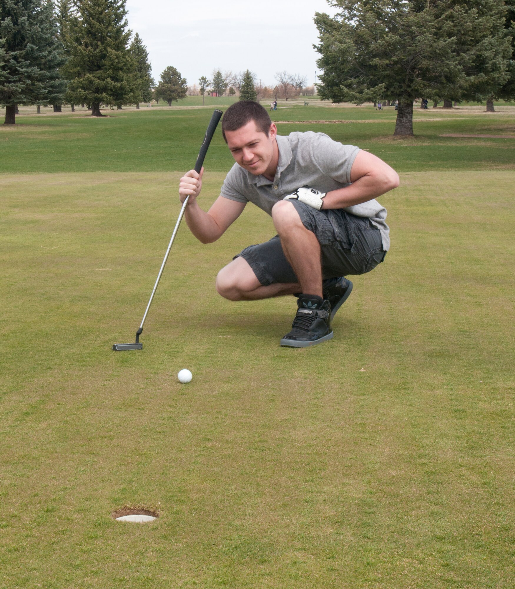 Senior Airman Darrin Grooms, 90th Security Forces Squadron, lines up a putt on the F.E. Warren Golf Course April 22, 2014. Warmer weather means fairways are free from snow and ice; it is the time of year to really enjoy outdoor activities once again. (U.S. Air Force photo by Airman 1st Class Jason Wiese)