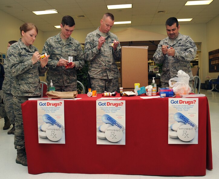 Members from the 2nd Medical Group and 2nd Security Forces Squadron cross out personal information on pill bottles medication during the nation-wide Prescription Drug Take-Back Day at the Exchange on Barksdale Air Force Base, La., April 23, 2014. Last year, more than 300 lbs. of drugs were received and destroyed. (U.S. Air Force photo/Staff Sgt. Sean Martin)