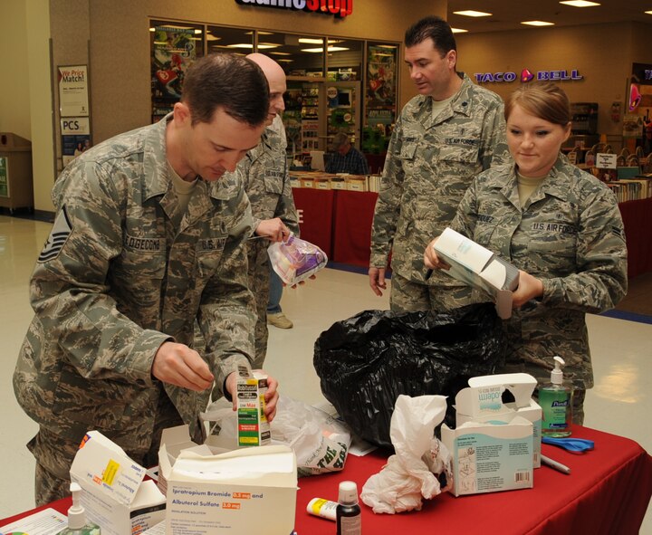 Master Sgt. Christopher Edgecomb, front left, 2nd Medical Support Squadron pharmacy flight chief, and Airman 1st Class Jewells Henriquez, 2nd Medical Operations Squadron Alcohol Drug Abuse and Prevention Treatment, sort through a bag of medication during the nation-wide Prescription Drug Take-Back Day at the Exchange on Barksdale Air Force Base, La., April 23, 2014. The 2nd Medical Group and 2nd Security Forces Squadron collected potentially dangerous, expired, unused or unwanted prescription drugs to be destroyed. (U.S. Air Force photo/Staff Sgt. Sean Martin)