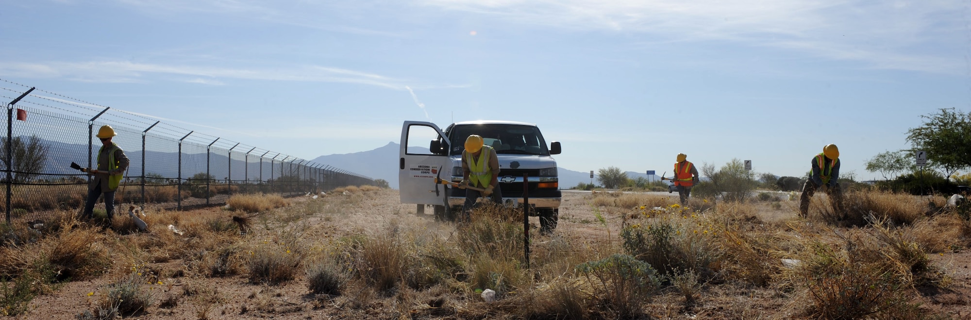 A crew from the Arizona Conservation Corps removes buffelgrass outside the fence line at Davis-Monthan Air Force Base, Ariz., April 22, 2014. The buffelgrass is an invasive species that fills the open areas of the Sonoran Desert which poses a threat for possible fires. (U.S. Air Force photo by Airman 1st Class Cheyenne Morigeau/ Released)