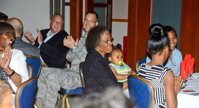 Hettie Neel is applauded by her family friends and members of the 22nd Force Support Squadron, during her retirement ceremony, April 22, 2014, at McConnell Air Force Base, Kan. She served as a child care provider for 42 years and will continue to help take care of her great grandchildren after her retirement. (U.S. Air Force photo/Airman 1st Class John Linzmeier) 