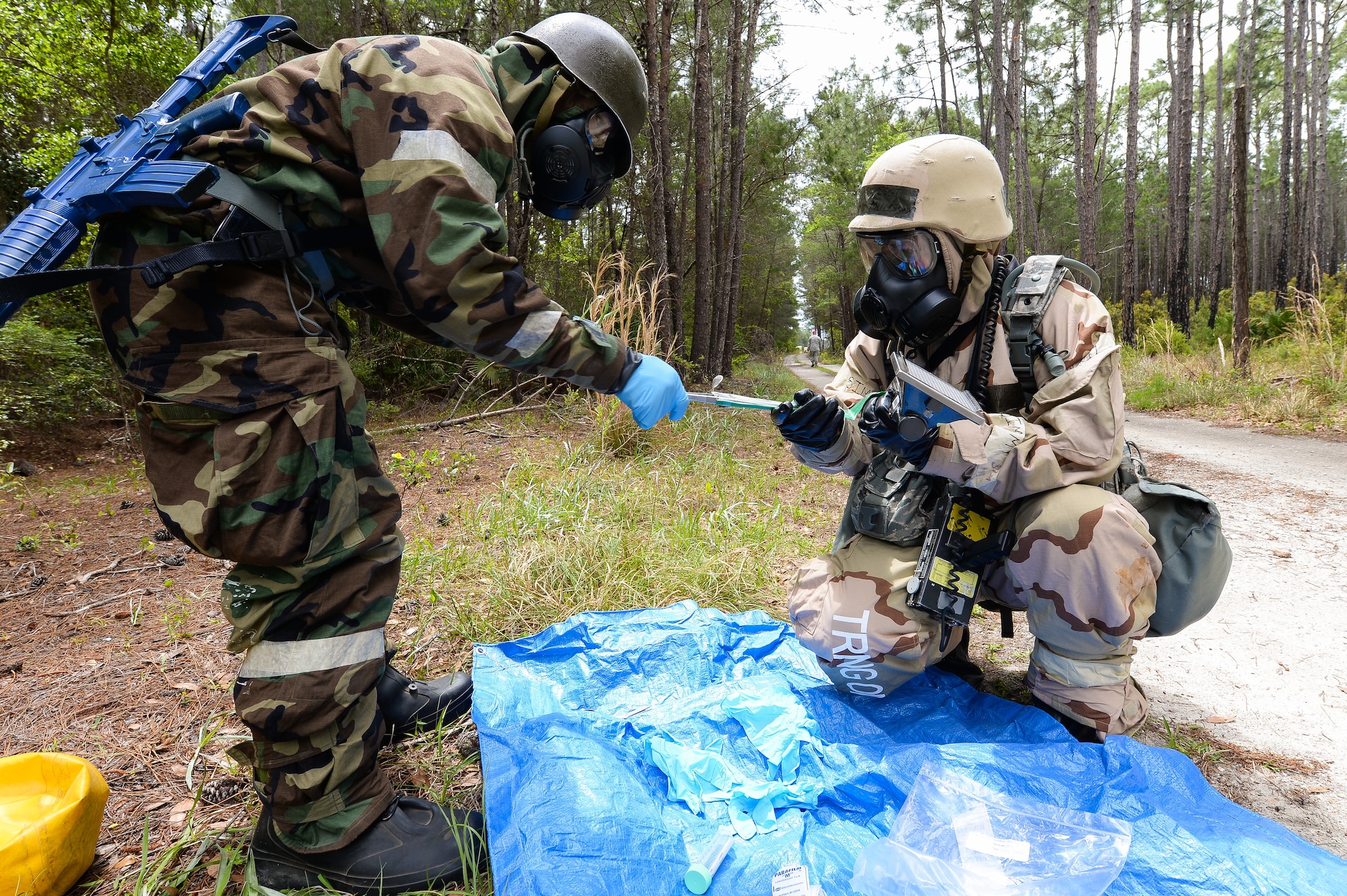 U.S. Air Force Staff Sgt. Edgar Mullinax, right, emergency management specialist with the 116th Civil Engineering Squadron (CES), Georgia Air National Guard (ANG), Robins Air Force Base, Ga., and Staff Sgt. Im Southavout, emergency management specialist with the 5th CES, Minot Air Force Base, N.D., test vegetation for radiological contamination at Silver Flag training at Tyndall Air Force Base, Fla., April 17, 2014. During the weeklong course, Guardsmen from the 116th CES along with 219 Airmen from multiple U.S. Air Force active duty, Reserve and Air National Guard units trained on building and maintaining bare-base operations at a simulated forward-deployed location. In addition, they honed their combat and survival skills, repaired simulated bomb-damaged runways, practiced EOD scenarios, set up base facilities and established various critical base operating support capabilities. Thirty-four Airmen from the 116th CES attended the exercise that consisted of extensive classroom and hands-on training culminating in an evaluation of learned skills on the last day of class. (U.S. Air National Guard photo by Master Sgt. Roger Parsons/Released)