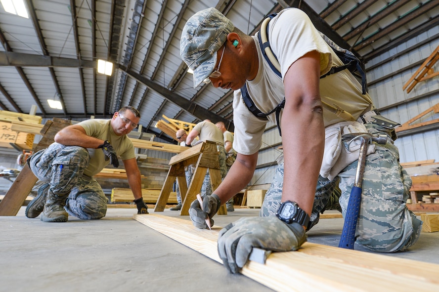 U.S. Air Force Senior Airman Terrell Green, right, from the 116th Civil Engineering Squadron (CES), Georgia Air National Guard, Robins Air Force Base, Ga., marks a measurement on a wall frame under the watchful eye of Tech. Sgt. Roger Jalette, 143rd CES, Quonset National Guard Base, R.I., during Silver Flag training at Tyndall Air Force Base, Fla., April 15, 2014. During the weeklong course, Guardsmen from the 116th CES along with 219 Airmen from multiple U.S. Air Force active duty, Reserve and Air National Guard units trained on building and maintaining bare-base operations at a simulated forward-deployed location. In addition, they honed their combat and survival skills, repaired simulated bomb-damaged runways, set up base facilities and established various critical base operating support capabilities. Thirty-four Airmen from the 116th CES attended the exercise that consisted of extensive classroom and hands-on training culminating in an evaluation of learned skills on the last day of class. (U.S. Air National Guard photo by Master Sgt. Roger Parsons/Released)