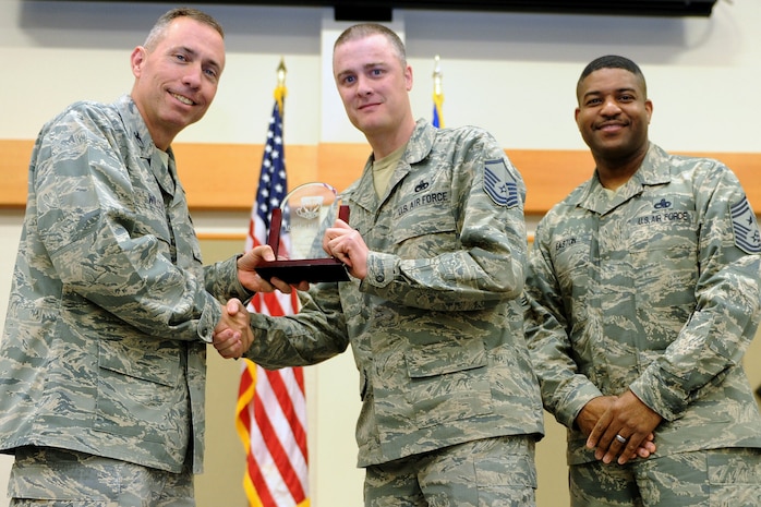 Master Sgt. Mark McLaughlin, 341st Operations Support Squadron, center, was named Malmstrom AFB's Senior Noncommissioned Officer of the Quarter for the first quarter of 2014.  Shown presenting the award are Col. John Wilcox, 341st Missile Wing commander, and Chief Master Sgt. Phillip Easton, 341 MW command chief.  The presentation was made at the Wing Quarterly Professional Awards ceremony held April 19 at the Grizzly Bend.  (U.S. Air Force photo/ Senior Airman Katrina Heikkinen)