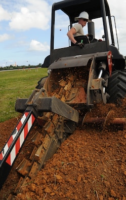 U.S. Air Force Airman 1st Class Jake Shroader, 18th Communications Squadron cable and antenna systems technician, uses a trencher to dig a hole for fiber optic cable during a fiber optic installation to the airfield on Kadena Air Base, Japan, April 14, 2014. A trencher is a piece of construction equipment used to dig trenches, especially for laying pipes or cables. (U.S. Air Force photo by Airman 1st Class Keith James)