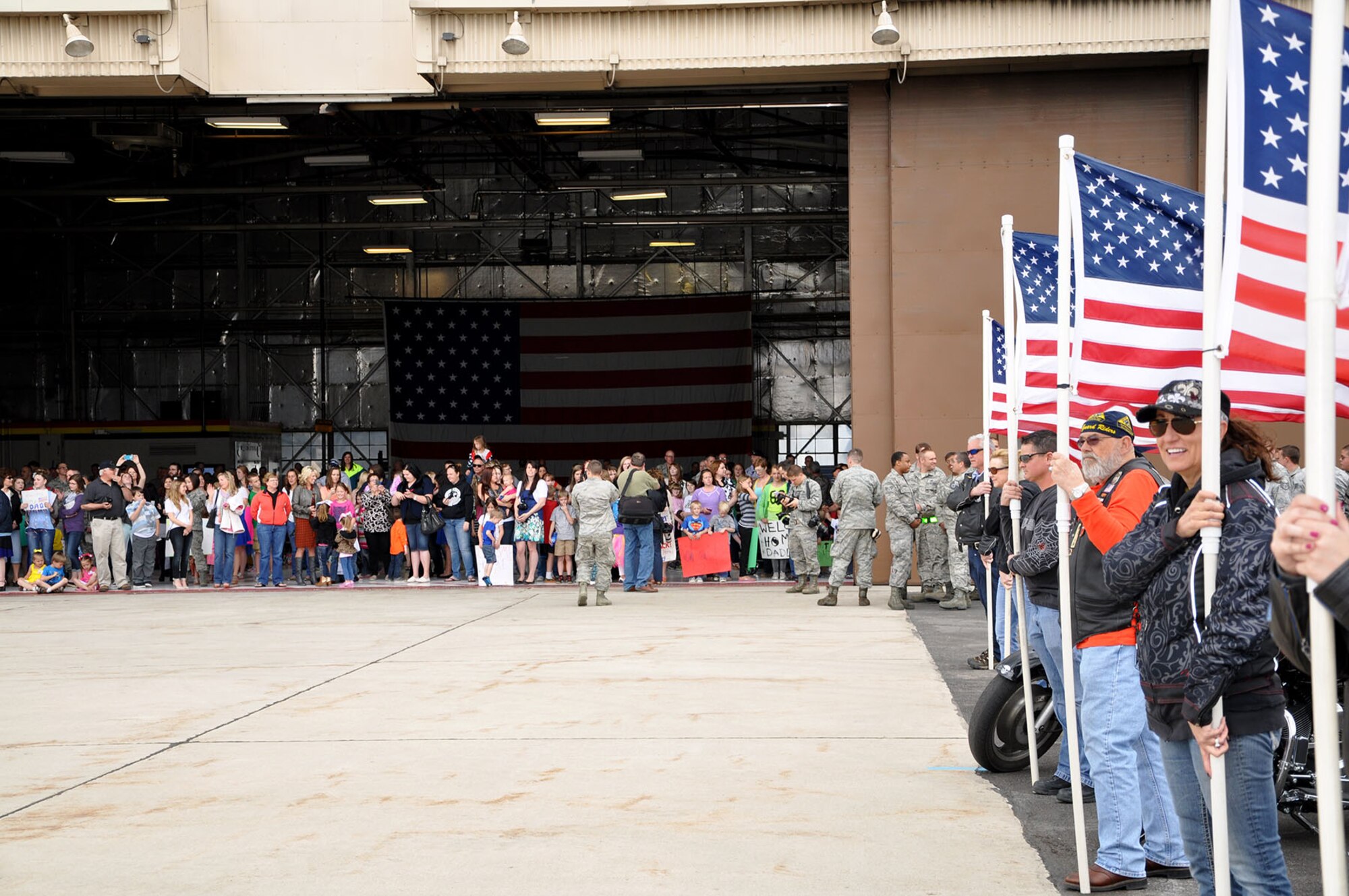 Families and friends wait near the flightline for the return of about 130 Airmen coming home from the Republic of Korea. Active-duty and Reserve Airmen from the 388th Fighter Wing and 419th Fighter Wing were deployed for four months in support of a routine Theater Security Package rotation. (U.S. Air Force photo/Bryan Magaña)