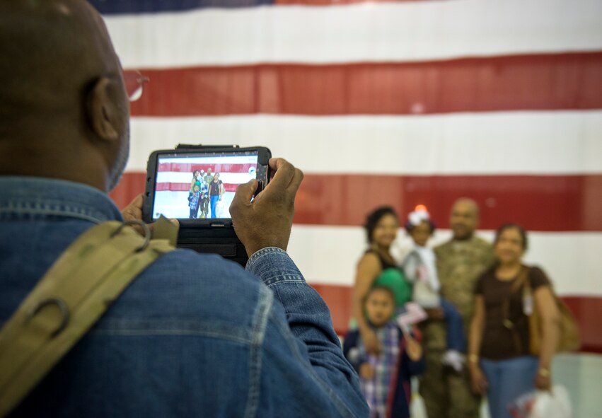 Al Shields takes a photo of U.S. Air Force Tech. Sgt. Warren Shields and the rest of his family during a deployment return at Moody Air Force Base, Ga., April 22, 2014. During the return, a local band, The Georgia Allstars, played patriotic music and two motorcycle clubs, the Moody Green Knights and the Patriot Guard, welcomed the returning Airmen home. (U.S. Air Force photo by Senior Airman Jarrod Grammel/Released)
