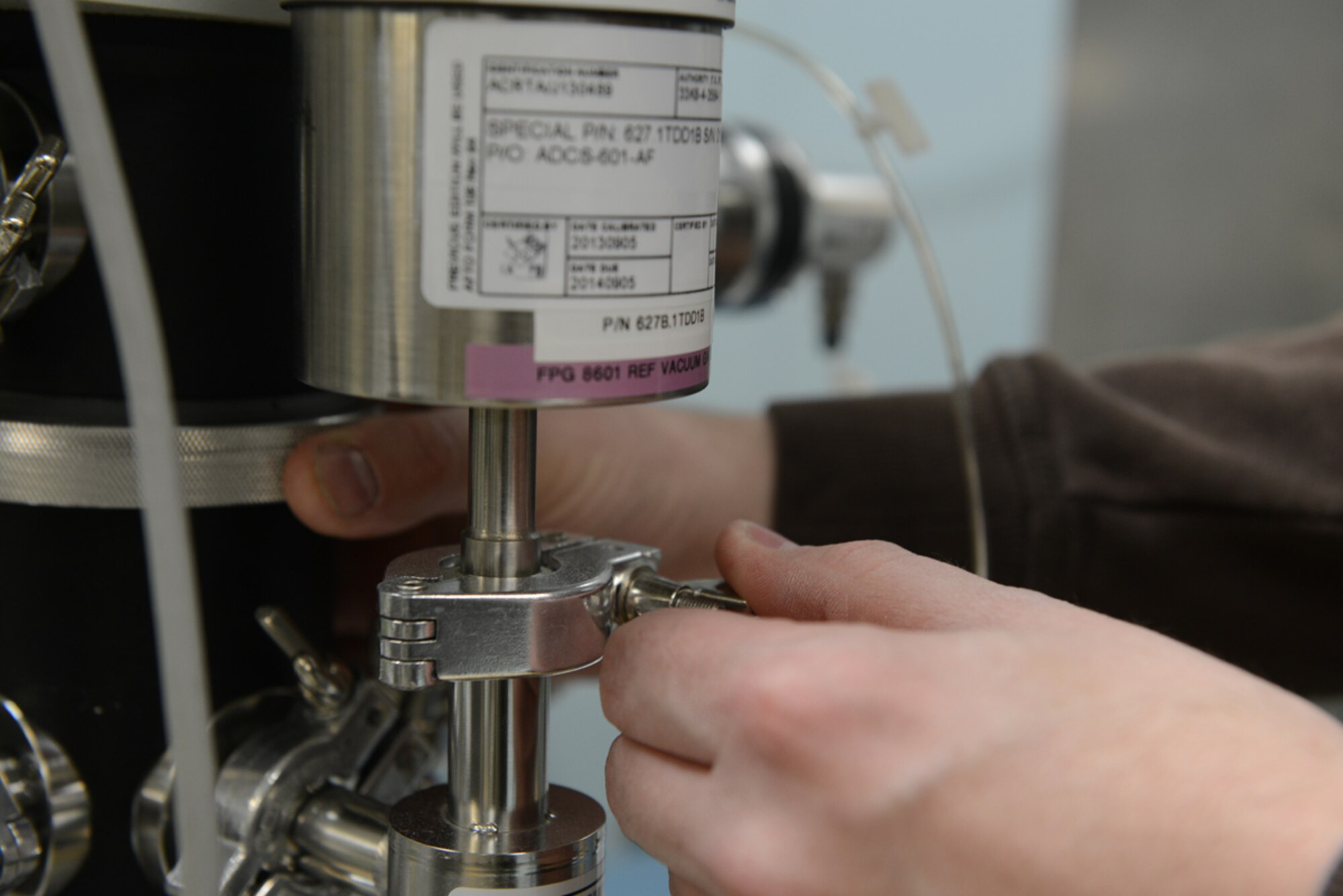 JOINT BASE ELMENDORF-RICHARDSON-- Aaron Hug, 3rd Maintenance Squadron Precision Maintenance Equipment Lab technician, configures an Air Data Calibrations Standard-601's capacitance diaphragm gauge at the PMEL on Joint Base Elmendorf-Richardson, Alaska, April 16, 2014. The ADCS-601 AF is a device used to calibrate various air data range instruments. The mission of the JBER PMEL is to provide support by electronic and mechanical calibration of Air data machines. (U.S. Air Force photo/Airman 1st Class Ty-Rico Lea)