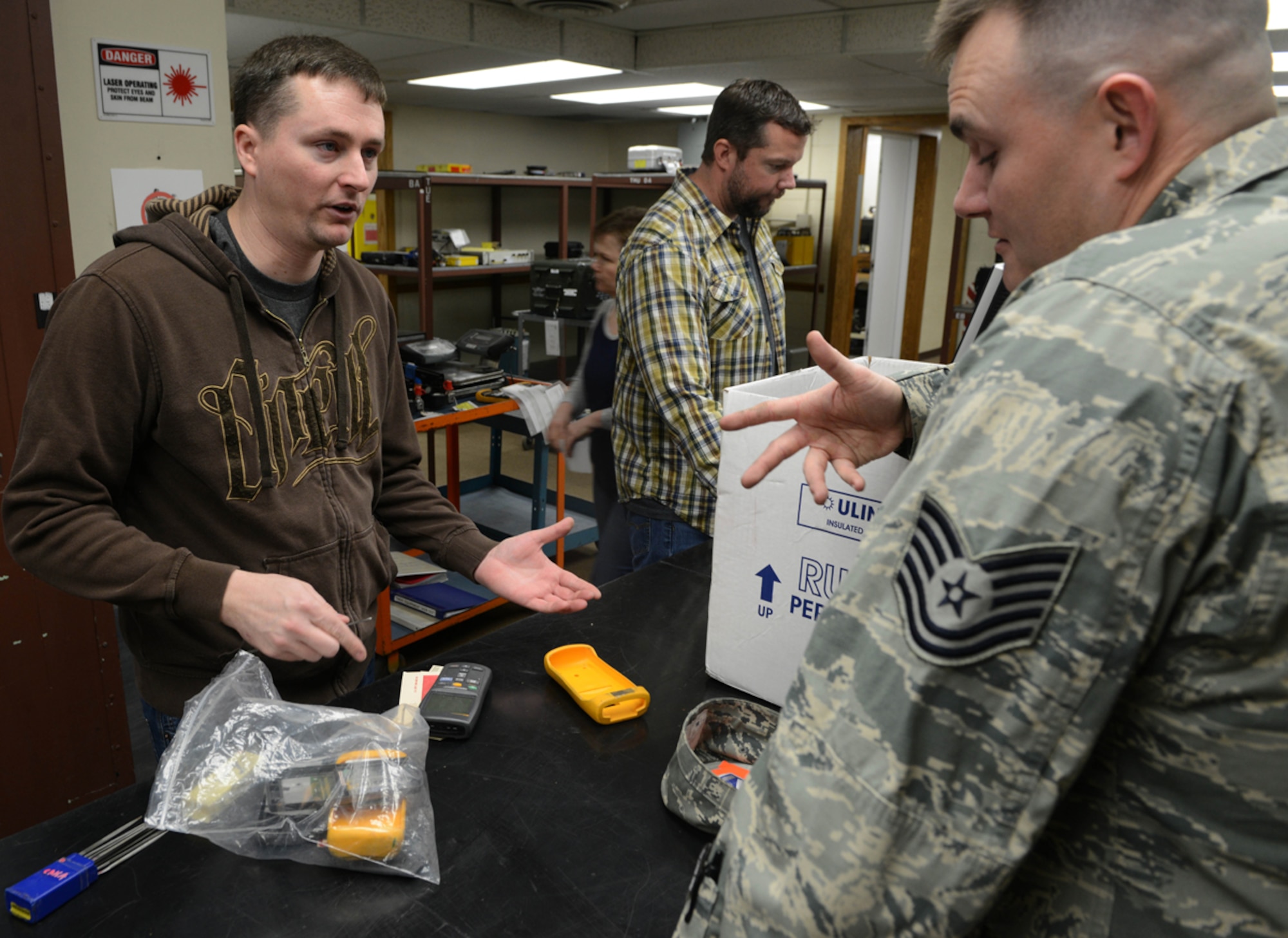 JOINT BASE ELMENDORF-RICHARDSON-- Aaron Hug, 3rd Maintenance Squadron Precision Maintenance Equipment Lab technician, assist Tech. Sgt. Brandon Denmon, 3rd Maintenance Squadron low observable structural maintenance craftsman, with inspecting a digital thermometer at the PMEL on Joint Base Elmendorf-Richardson, Alaska, April 16, 2014. The PMEL is under the Type IIA Test Measurement Diagnostic Equipment Flight and is responsible to provide calibration, repair and traceability. (U.S. Air Force photo/Airman 1st Class Ty-Rico Lea)