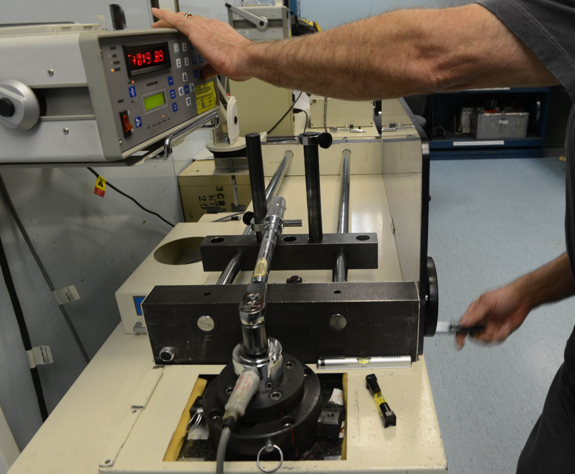 JOINT BASE ELMENDORF-RICHARDSON-- A Precision Measurement Equipment Lab technician adjusts the grip of a torque wrench using a torques calibrator machine at the PMEL on Joint Base Elmendorf-Richardson, Alaska, April 16, 2014. The PMEL is a contracted facility whcih is within the 3rd Wing. (U.S. Air Force photo/Airman 1st Class Ty-Rico Lea)