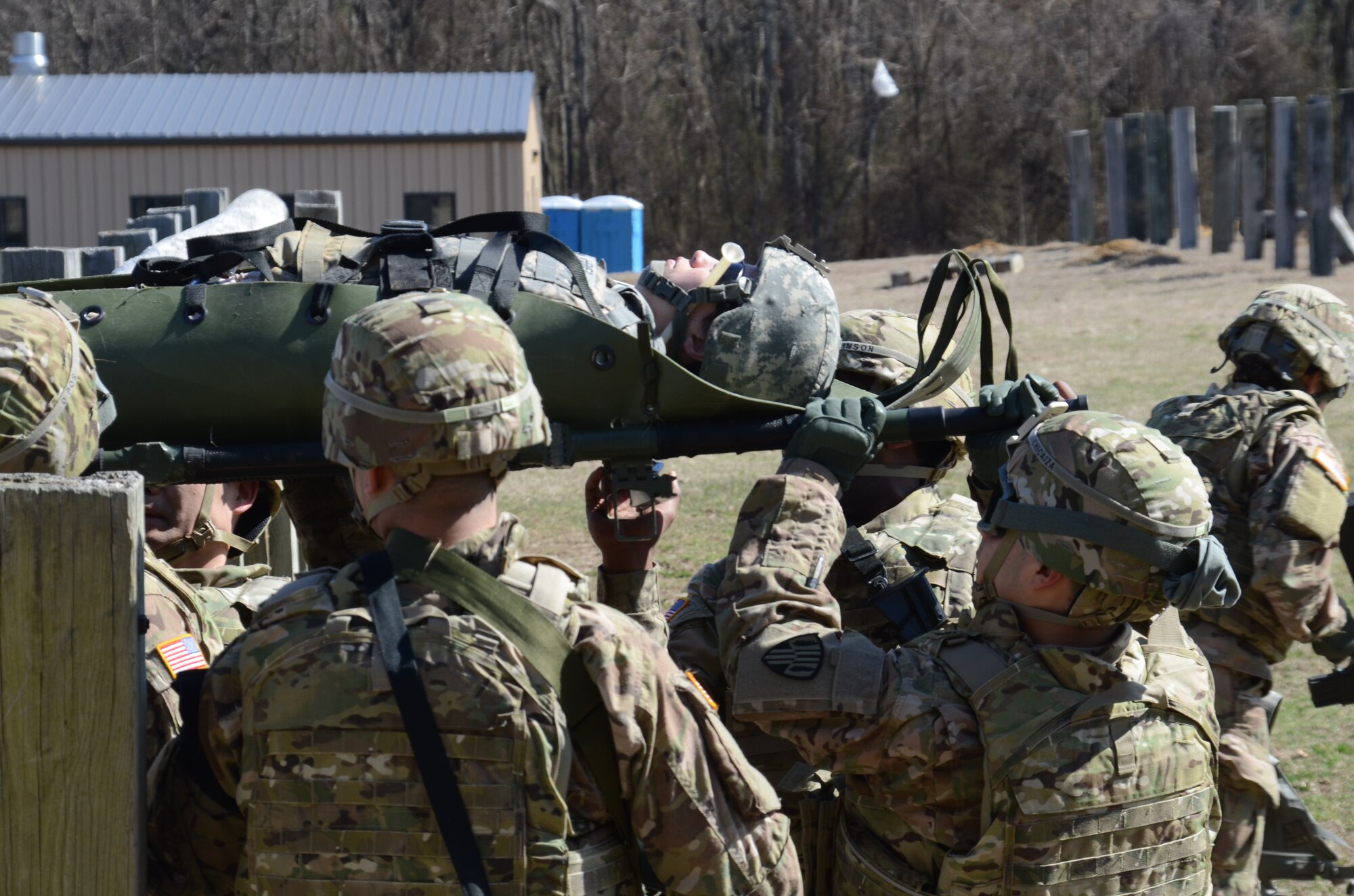 Soldiers with the 4th Finance Detachment from the New York National Guard Navigate a simulated casualty over a six-foot wall as part of a practical evaluation for a Combat Lifesaver course conducted on Joint Base McGuire-Dix-Lakehurst, N.J., on April 1, 2014. The Soldiers completed CLS as part of their pre-deployment training for Afghanistan.(National Guard photo by Staff Sgt. John Etheridge/Released)