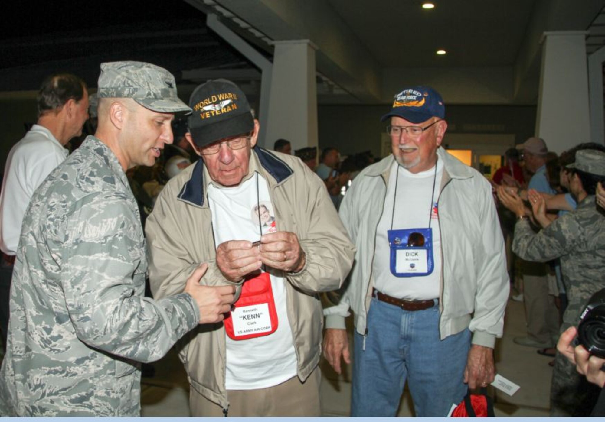 Col. Robert Pavelko, 45th Space Wing vice commander, gives an Honor Flight coin to retired U.S. Army Air Corps 1st Lt. Kenneth Clark, at the Honor Flight departure in Melbourne, Fla. April 12. Team Patrick-Cape volunteers were in attendance and met with World War II and Korean War veterans prior to flying to Washington D.C. to tour the U.S. Air Force Memorial, war memorials, and Arlington Cemetery, as part of the Honor Flight program. (Courtesy photo/Lou Seiler Jr.) 
