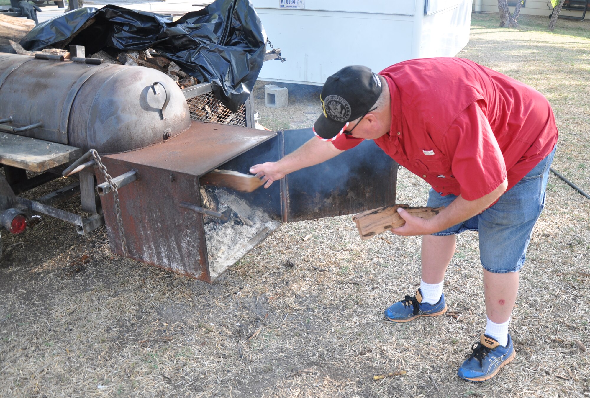GOODFELLOW AIR FORCE BASE, Texas – John M. Farris, Goodfellow Recreation Camp manager, adds mesquite wood to the smoker’s fire during a brisket cooking class at the rec. camp here April 19. Farris said that mesquite wood gives brisket the best smoky flavor. (U.S. Air Force photo/ Senior Airman Joshua Edwards)