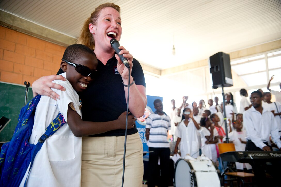 Staff Sgt. Jill Diem and a student sing with the U.S. Air Forces in Europe Band ensemble Touch n' Go at the Dom Bosco School in Luanda, Angola, March 26, 2014. The band is in Angola as part of African Partnership Flight Angola 2014, which is an event providing a collaborative learning environment for the Angolan, U.S. and Zambian air forces. (U.S. Air Force photo/Tech. Sgt. Benjamin Wilson)
