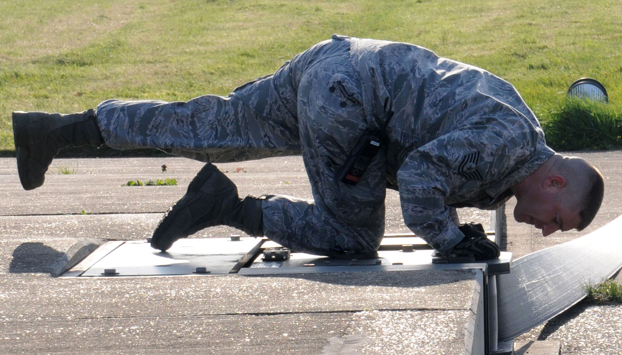 U.S. Air Force Tech. Sgt. Christopher Marrs, 100th Civil Engineer Squadron NCO in charge of electrical power production from Eugene, Ore., inspects a barrier as it’s reeled in April 17, 2014, on RAF Mildenhall, England. Marrs checked for proper reeling of the tape during rewind operations. If the tape is reeled incorrectly, it could be seriously damaged and cause the system to be inoperable. (U.S. Air Force photo by Gina Randall/Released)