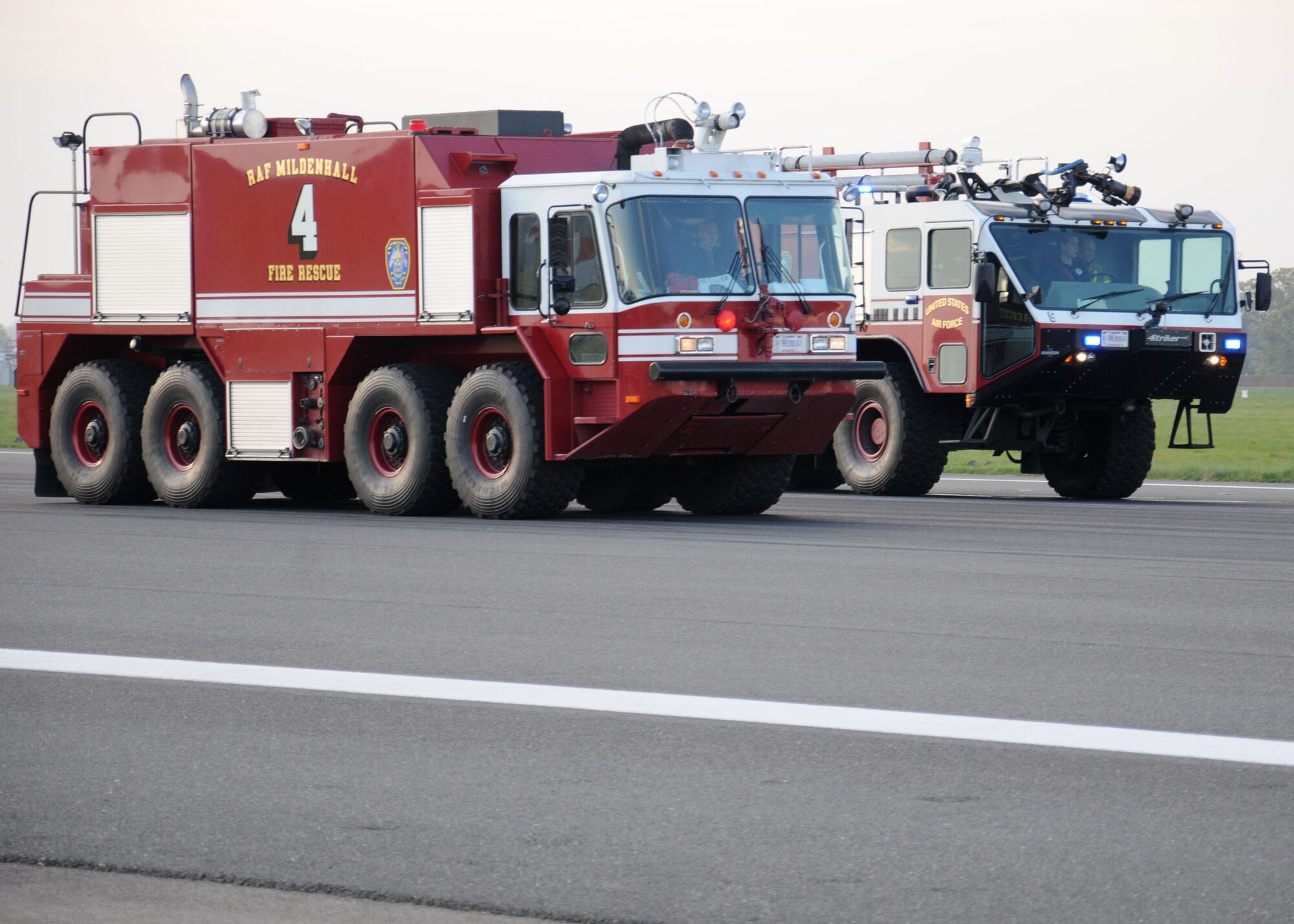 Fire trucks assigned to the 100th Civil Engineer Squadron Fire Department stand by on the runway April 17, 2014, during a barrier test on RAF Mildenhall, England. The fire department is in charge of inspecting an aircraft after an arrestment and conducting rewind operations to reset the barrier as quickly as possible. During an arrestment, the fire department will respond with several vehicles and multiple personnel. (U.S. Air Force photo by Gina Randall/Released)